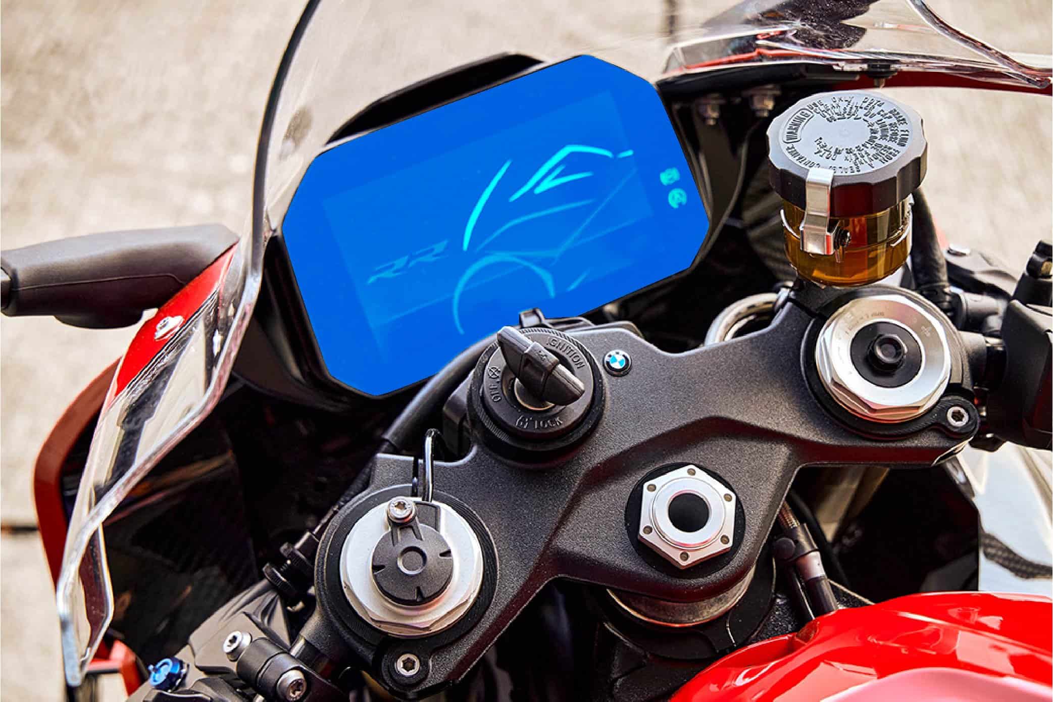 Close-up of motorcycle dashboard with digital display and controls.